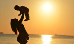 silhouette of mom and baby at beach