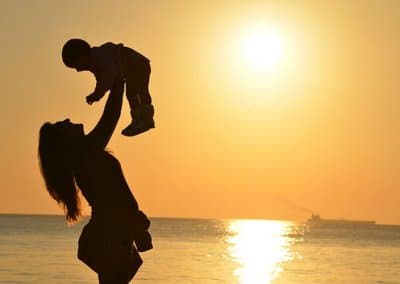 silhouette of mom and baby at beach