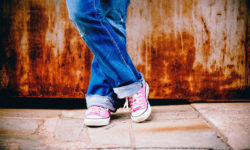 close-up-of-legs-and-pink converse-shoes-crossed