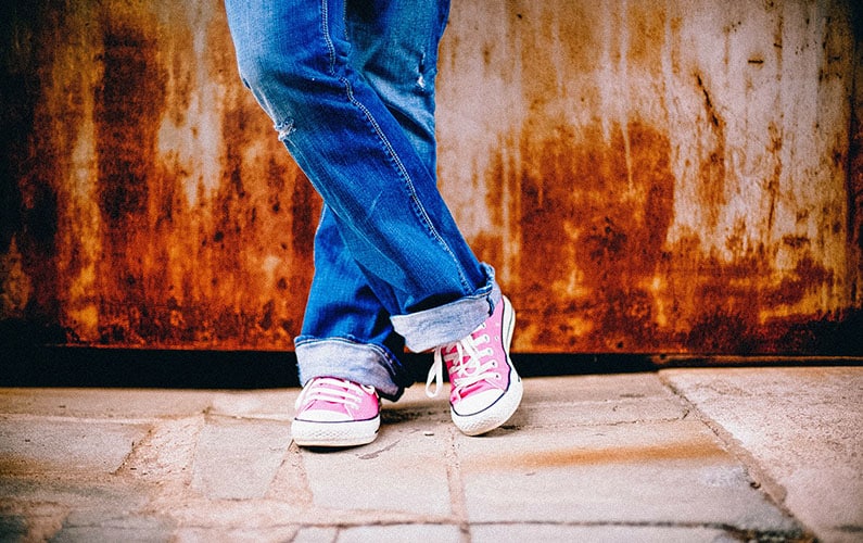 close-up-of-legs-and-pink converse-shoes-crossed